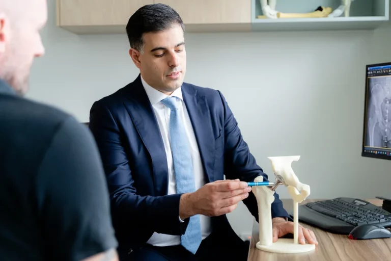 Orthopaedic surgeon explaining hip joint anatomy using anatomical model