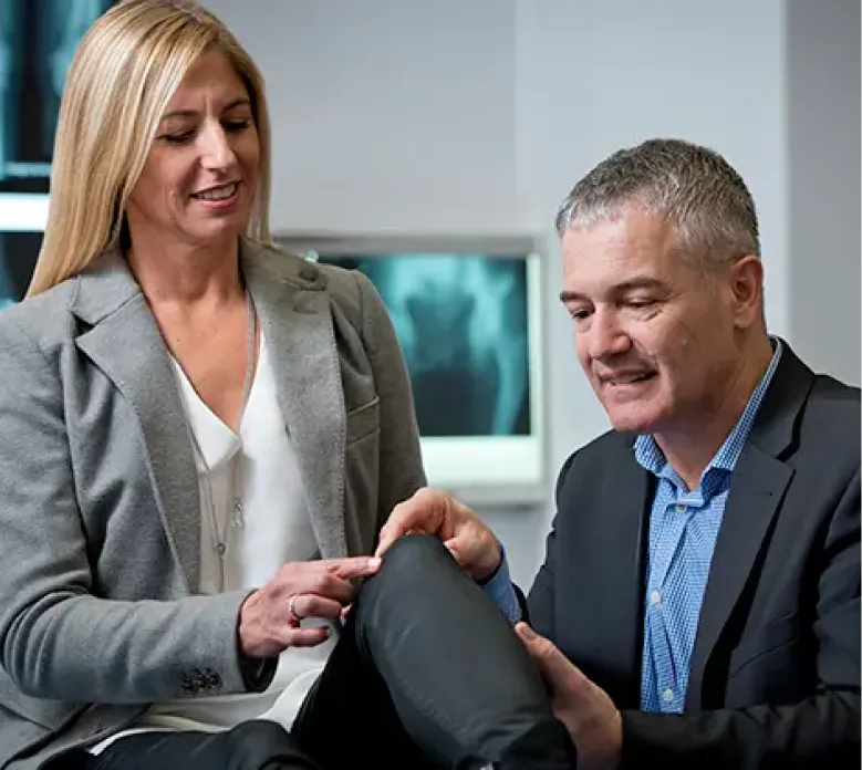 Orthopaedic specialist assessing patient's knee