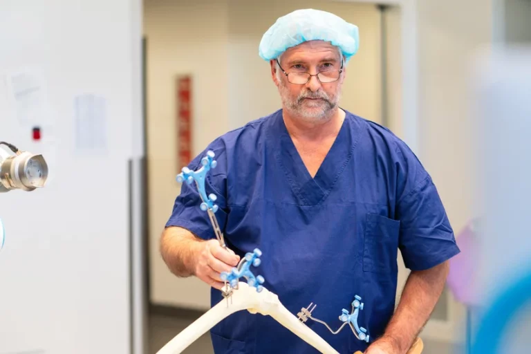 Orthopaedic surgeon in theatre attire, wearing surgical cap and scrubs