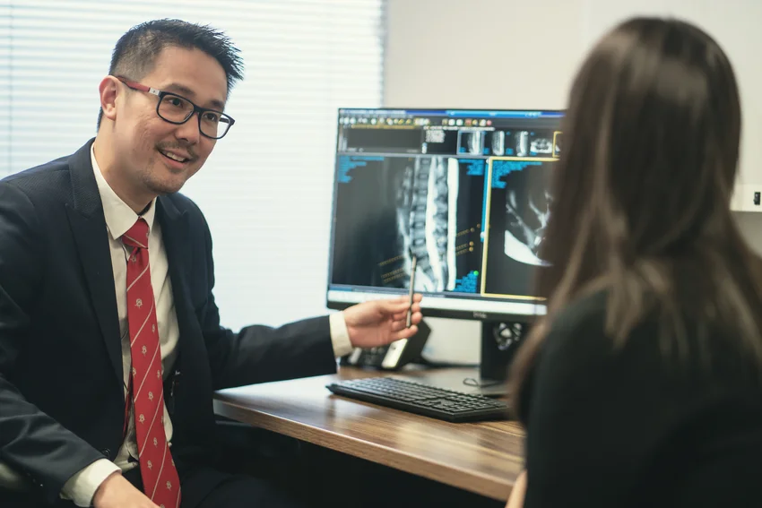 Healthcare practitioner examining patient's upper back during physical assessment