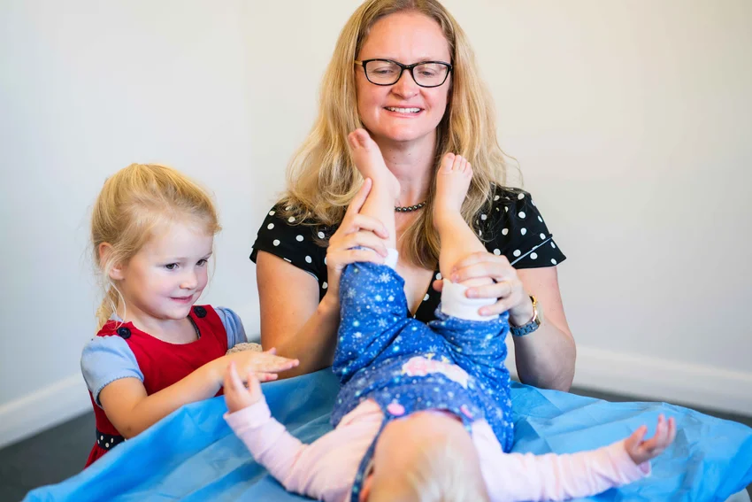Paediatric specialist examining young boy's knee in clinical setting